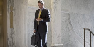 Caucasian politician using cell phone in government building