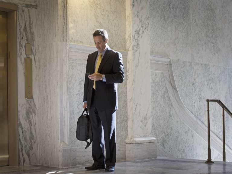 Caucasian politician using cell phone in government building