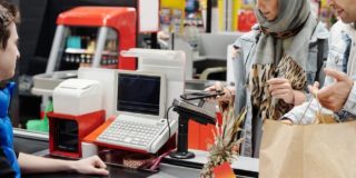 Customers standing in line waiting to pay a retail employee