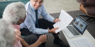 An insurance agent sitting at a table with clients