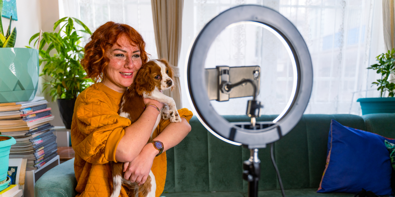 Hero image of an influencer a woman holding a dog with a ring light