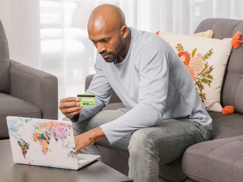 A financial services customer sitting in front of a laptop on his couch