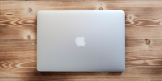 Hero image of a MacBook closed on a wooden desk