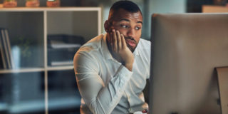 Meeting fatigue - man looking bored and tired in front of computer screen
