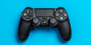 Flat Lay Photo of Black Sony PS4 Game Controller on Blue Background