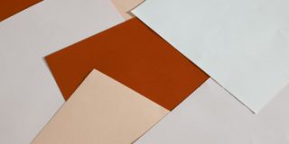 From above of blank paper sheets of different colors scattered on table as abstract background
