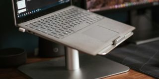 Modern laptop placed on stand on desk