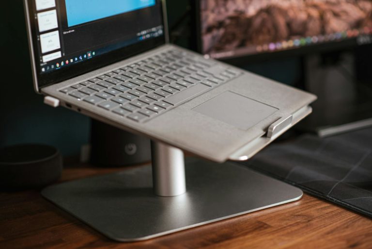 Modern laptop placed on stand on desk