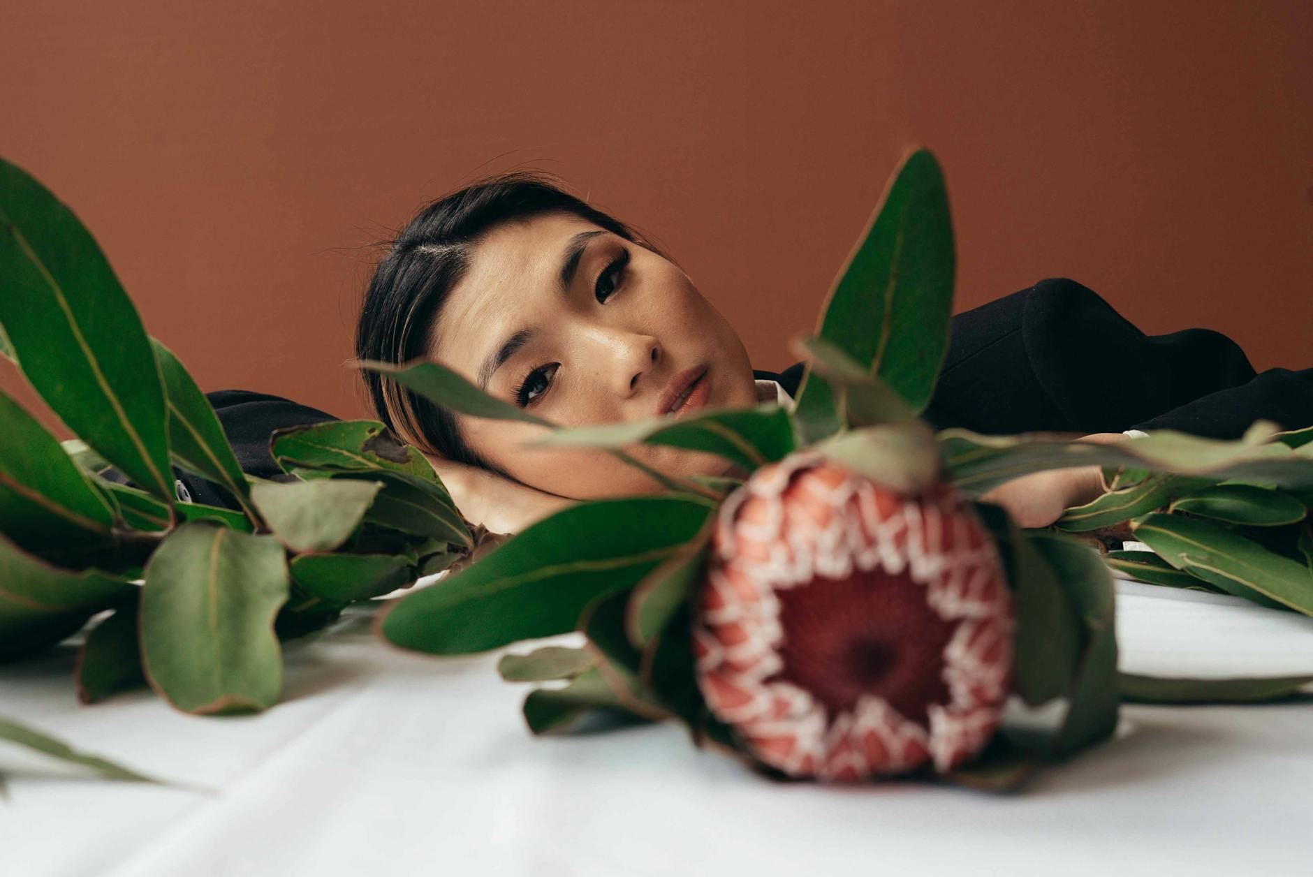 Ethnic woman with flowers on table