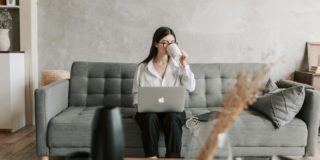 Woman Drinking Coffee While Working With Laptop