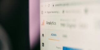 Close-up of a monitor showing a blurred analytics dashboard, with the word Analytics visible on a list of items.