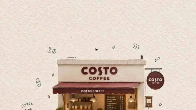 A Costa Coffee kiosk with a staff member serving customers at a small counter, sign reading COSTA COFFEE above, and two patrons seated at a table outside enjoying drinks.
