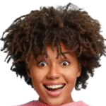 Close-up of a young woman with voluminous curly hair and a surprised, wide-eyed expression against a dark background, pink sweater visible at the collar